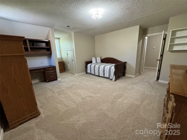 a spacious bedroom with a bed and a flat screen tv