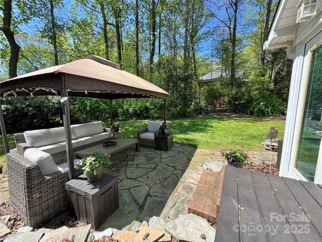 a view of a patio with table and chairs under an umbrella