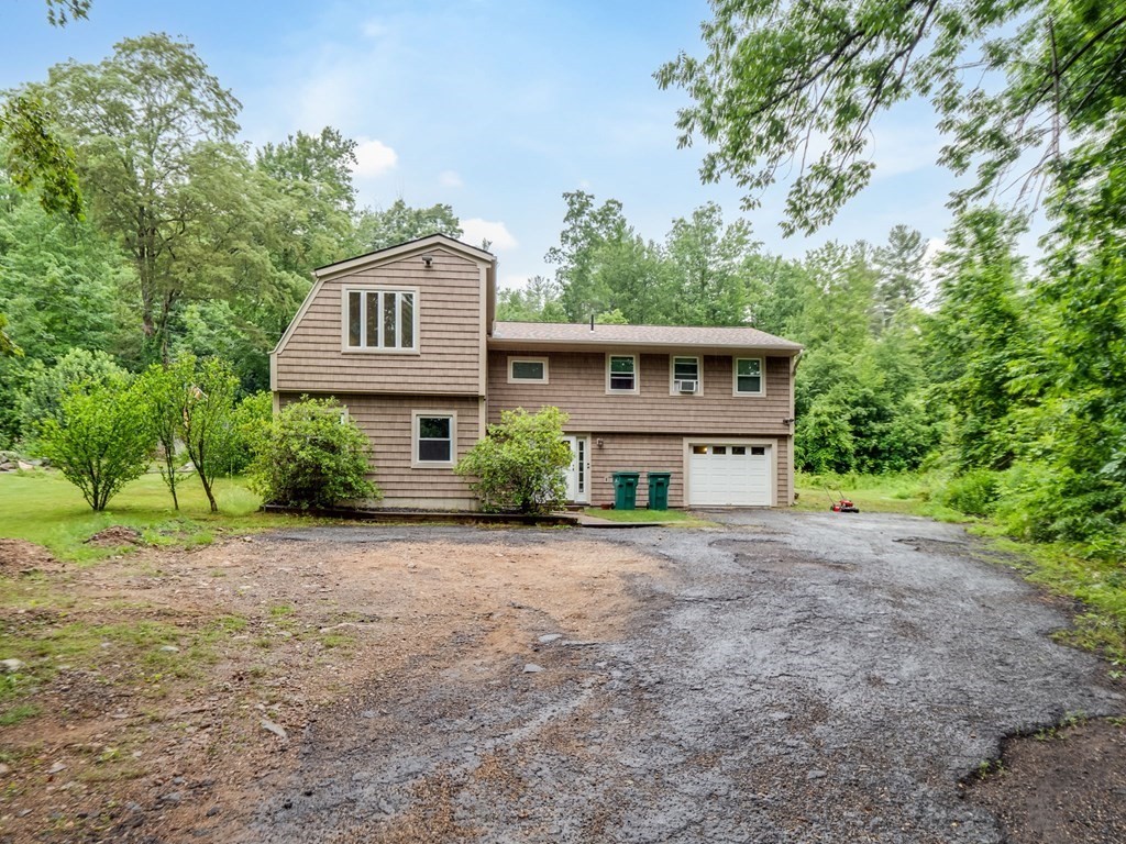 1850 North Brookfield Road Oakham, MA 01068 - Photo 2 of 42 a front view of a house with yard and trees