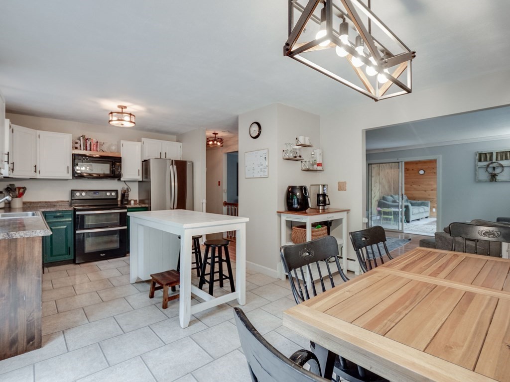 1850 North Brookfield Road Oakham, MA 01068 - Photo 23 of 42 a kitchen with stainless steel appliances kitchen island granite countertop a dining table chairs and a refrigerator