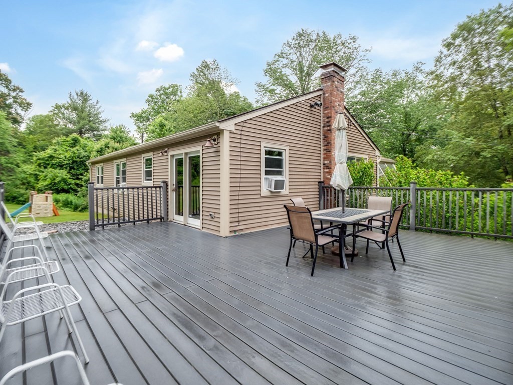 1850 North Brookfield Road Oakham, MA 01068 - Photo 6 of 42 a view of a house with wooden deck and furniture