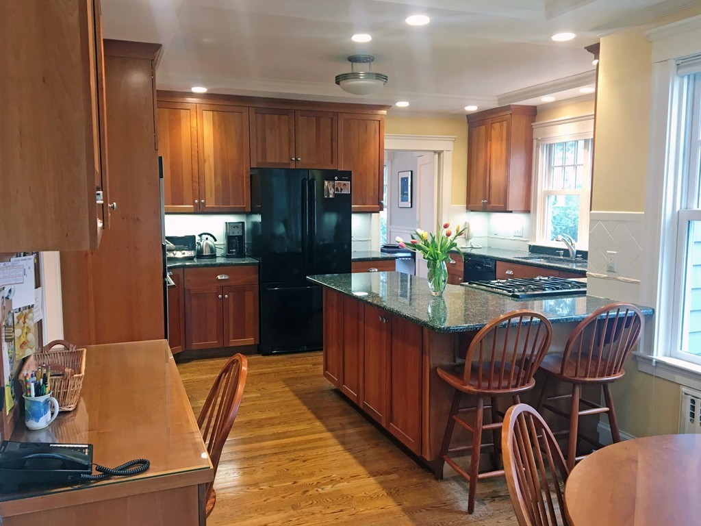12 Arlington Road Wellesley, MA 02481 - Photo 12 of 26 a kitchen with stainless steel appliances granite countertop a table chairs and a refrigerator