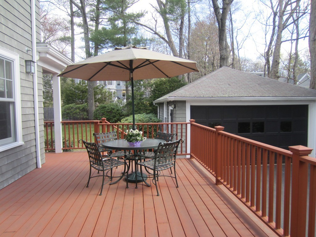 12 Arlington Road Wellesley, MA 02481 - Photo 25 of 26 a roof deck with a dining table and chairs under an umbrella with wooden floor