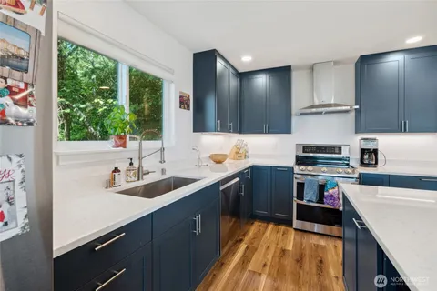 a kitchen with granite countertop a sink stove and cabinets