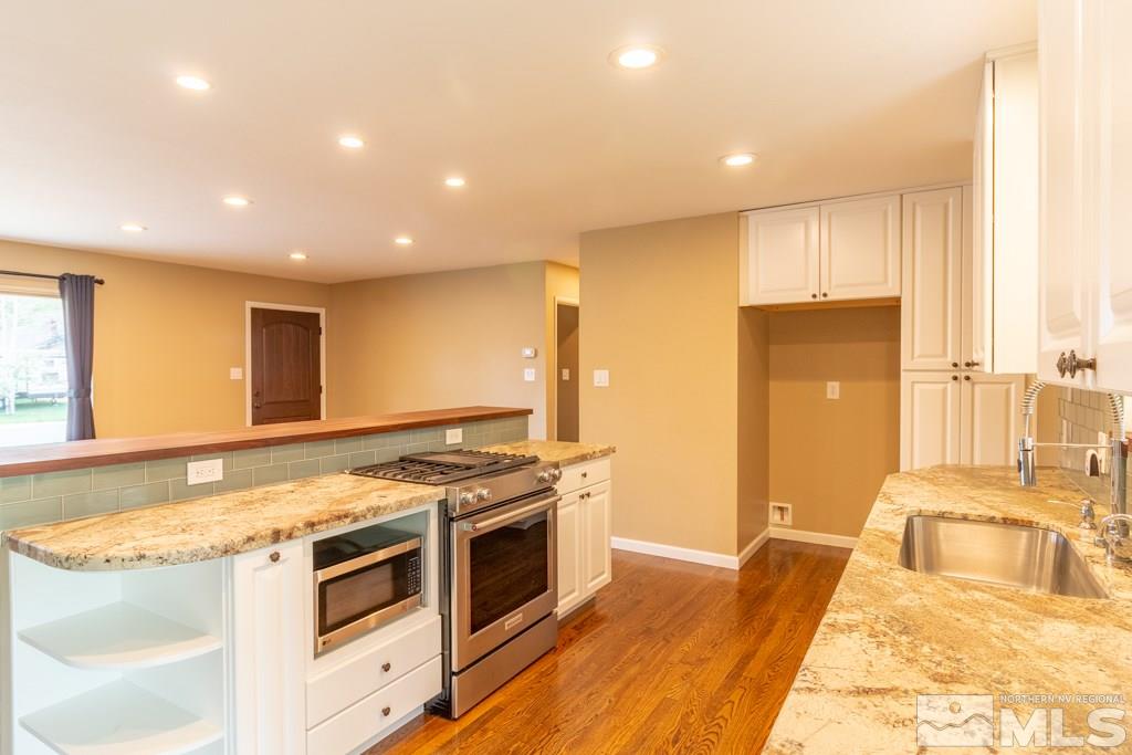 1415 Samuel Way Reno, NV 89509 - Photo 9 of 25 a kitchen with stainless steel appliances granite countertop a stove a sink and a refrigerator