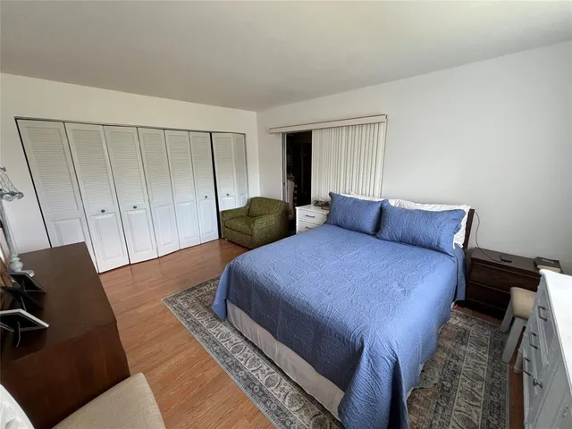 a bedroom with bed and wooden floor