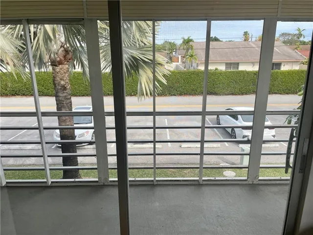 a view of a house with a window and palm tree