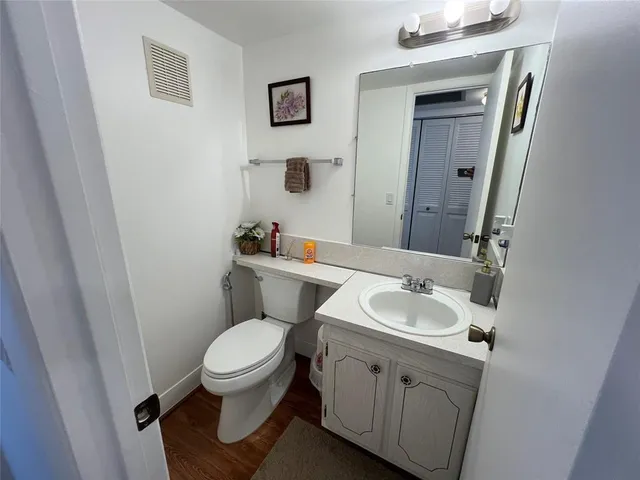 a bathroom with a granite countertop toilet a sink and a mirror
