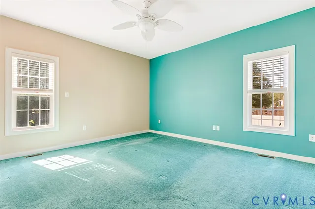 an empty room with a window and a kitchen