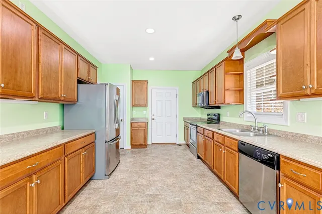 a large kitchen with stainless steel appliances granite countertop a sink refrigerator and cabinets