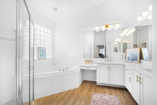 a bathroom with a tub sink and mirror