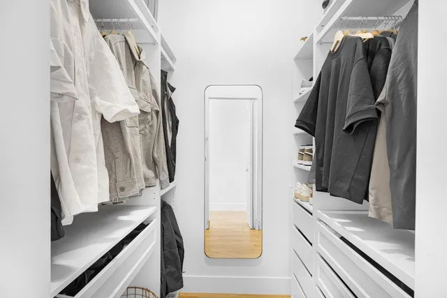 a view of walk in closet with clothes and shoes