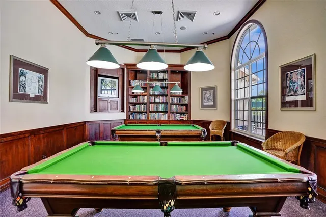 a room with pool table and windows