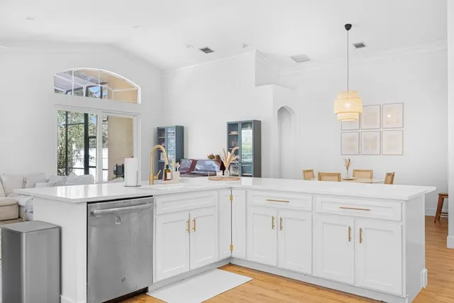 a kitchen with white cabinets and sink