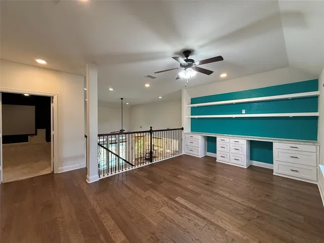 a view of an empty room with a window and a ceiling fan