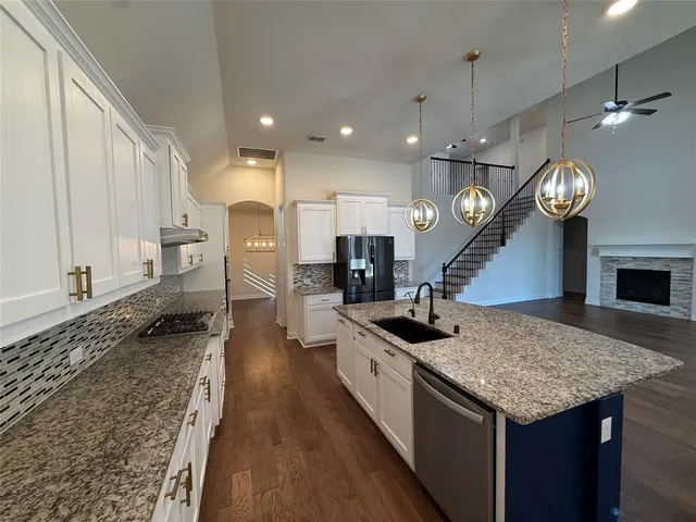 a kitchen with a stove center island and a wooden floor