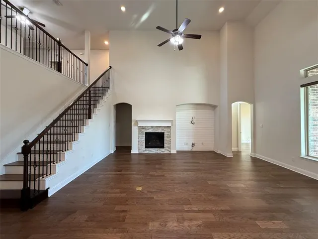 an empty room with windows and fireplace