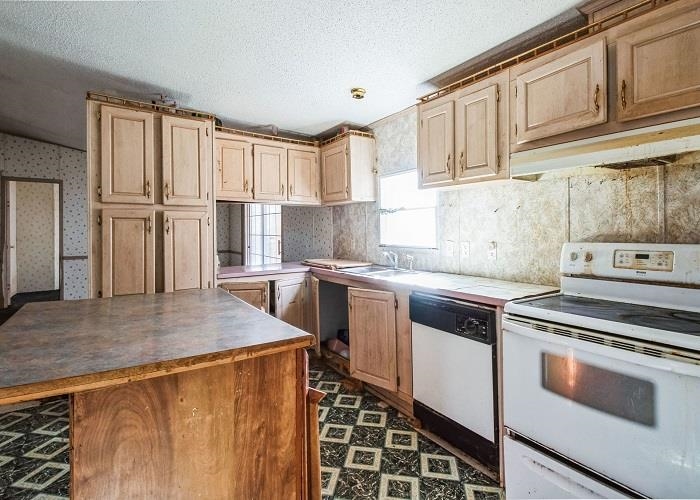 4414 Covey Hollow Road Culleoka, TN 38451 - Photo 7 of 16 a kitchen with stainless steel appliances granite countertop a stove a sink and a refrigerator