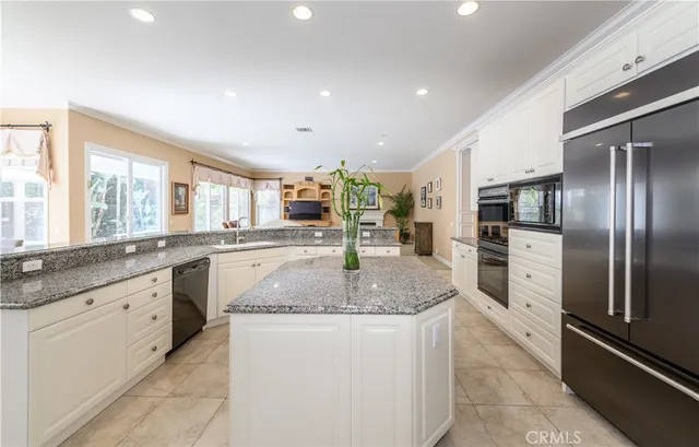 a large kitchen with kitchen island granite countertop a large counter top and stainless steel appliances