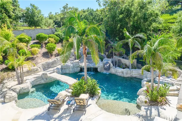 a view of a house with swimming pool and sitting area