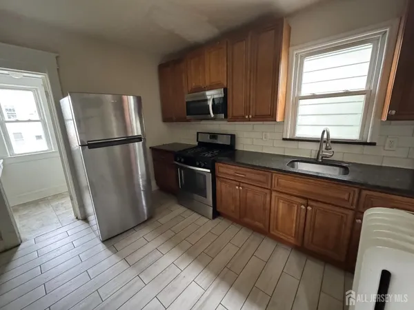 a kitchen with a refrigerator a sink a stove a microwave and cabinets