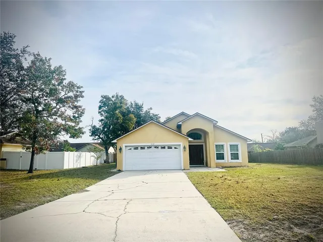 a view of a house with a yard and fence