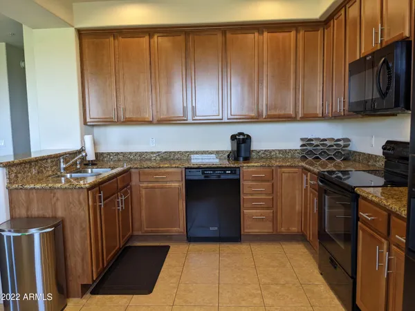 a kitchen with stainless steel appliances granite countertop a refrigerator and a stove top oven