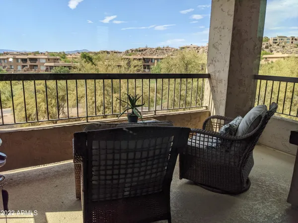 a view of a chairs and table in the balcony
