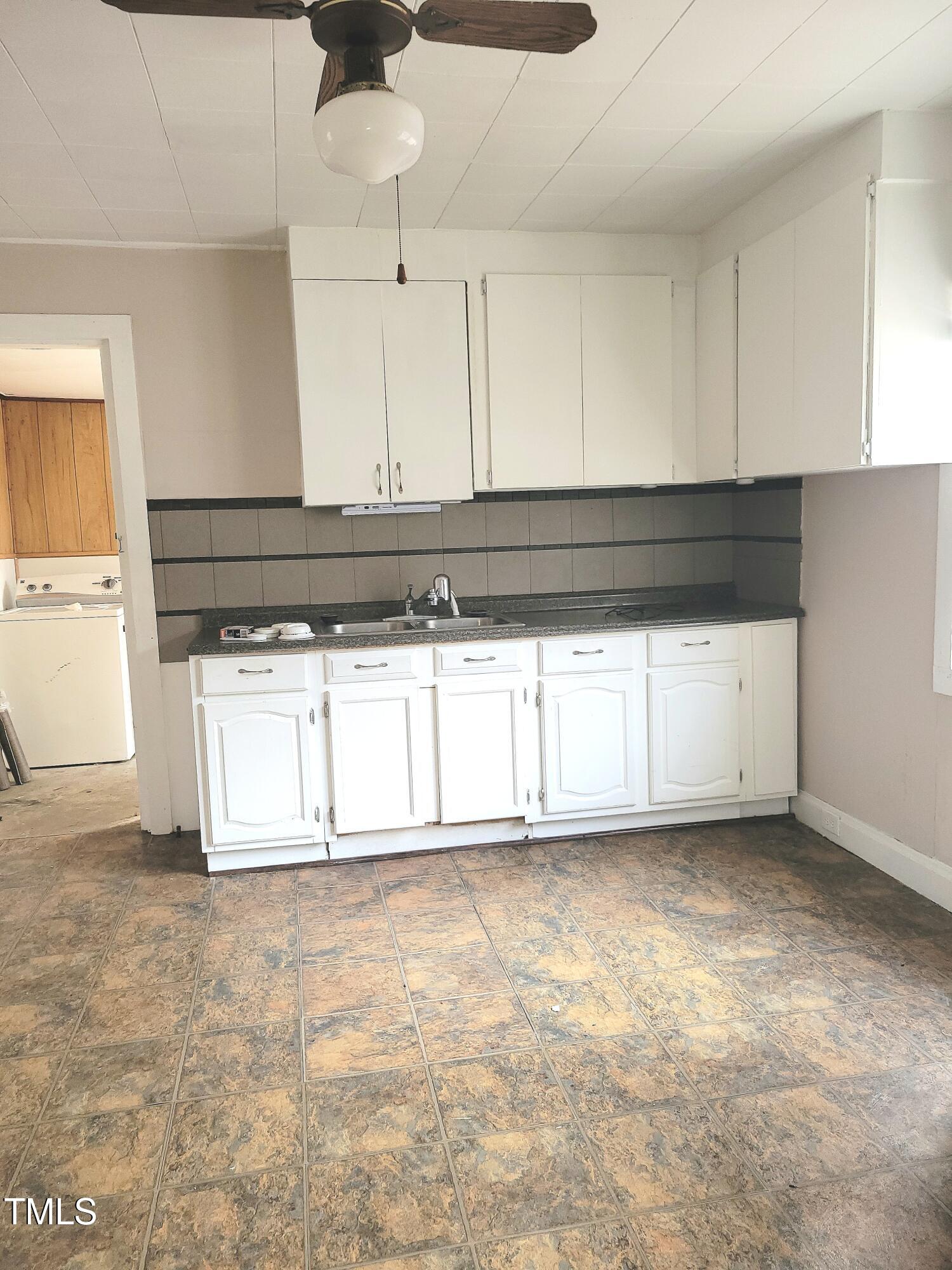 325 Ranch Farm Road, Unit A B Raleigh, NC 27603 - Photo 19 of 36 a kitchen with granite countertop a stove a sink and white cabinets