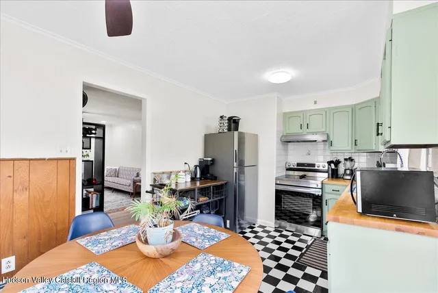 a kitchen with stainless steel appliances kitchen island granite countertop a refrigerator a stove a sink dishwasher with a dining table and chair