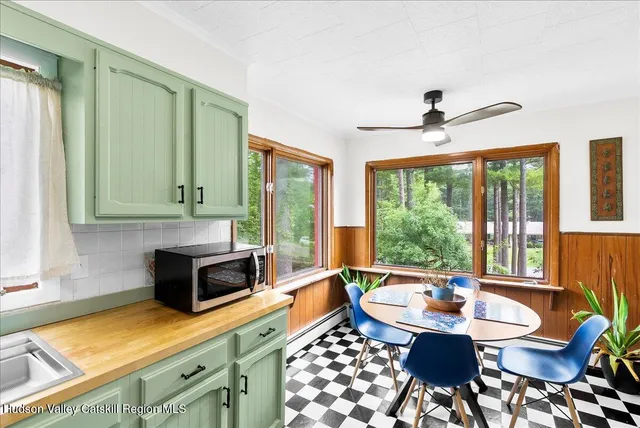 a kitchen with a stove a sink and a dining table with garden view
