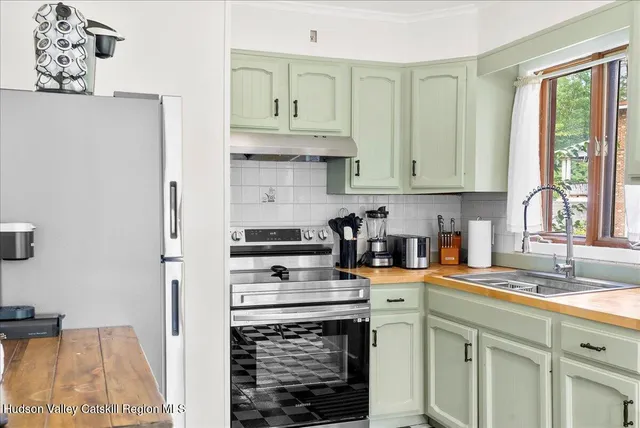 a kitchen with stainless steel appliances a stove a sink a refrigerator and cabinets