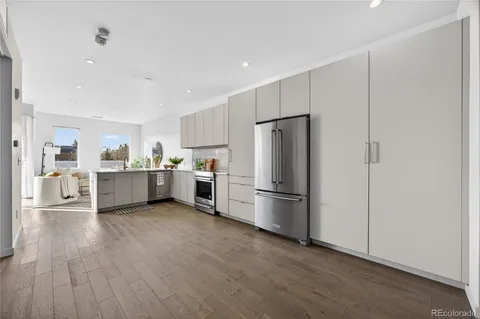 a kitchen with a refrigerator a sink and white cabinets