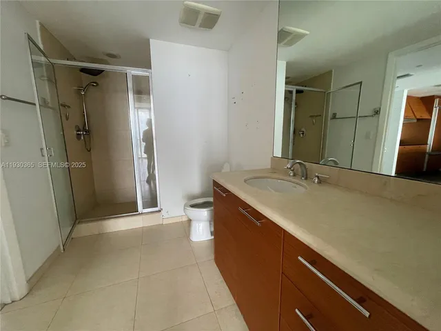 a bathroom with a double vanity sink toilet and shower