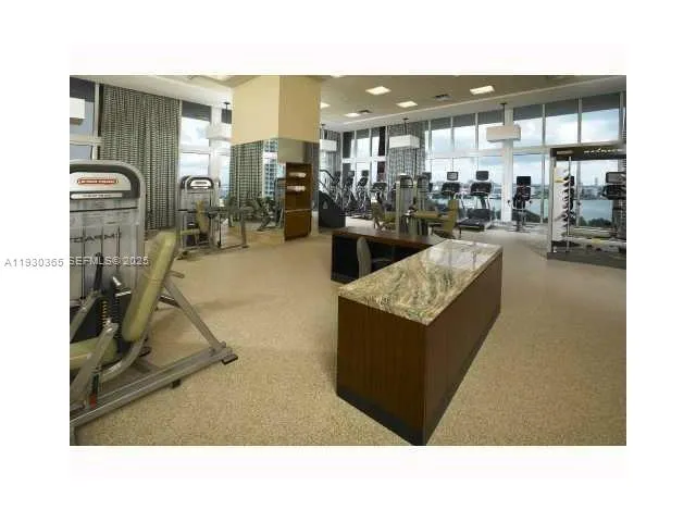 a living room with fireplace furniture and a view of kitchen
