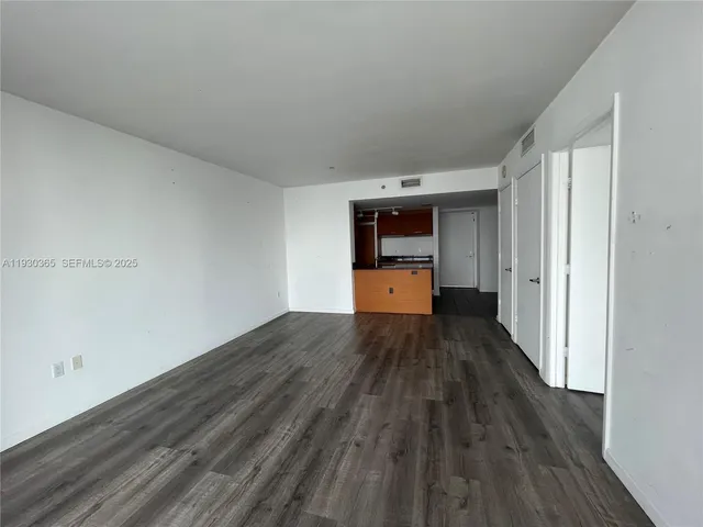 wooden floor in an empty room and a kitchen