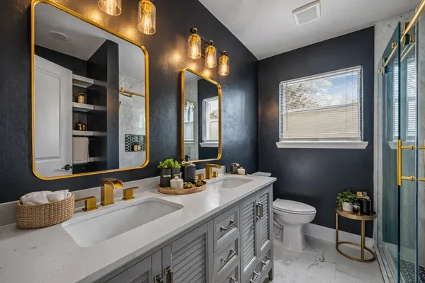 a bathroom with double vanity sinks a toilet and a mirror