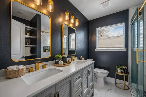 a bathroom with double vanity sinks a toilet and a mirror