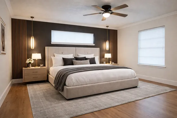 a bedroom with a large bed and a chandelier fan
