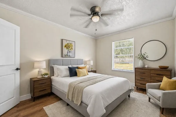 a spacious bedroom with a bed a couch and a chandelier