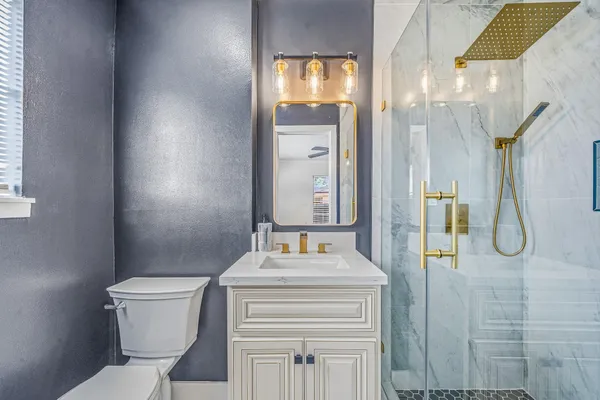 a bathroom with a granite countertop sink toilet and shower