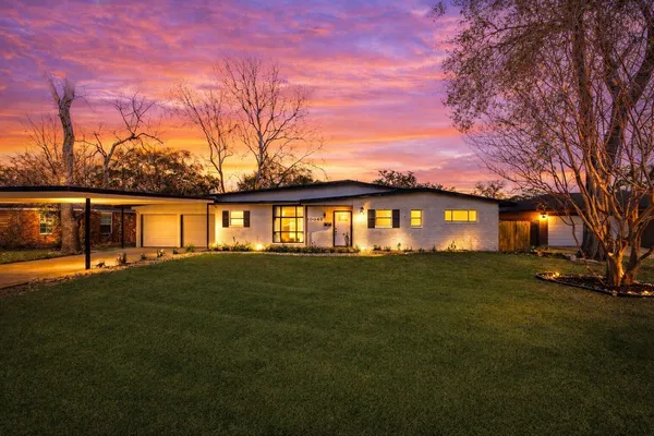 a front view of a house with a big yard