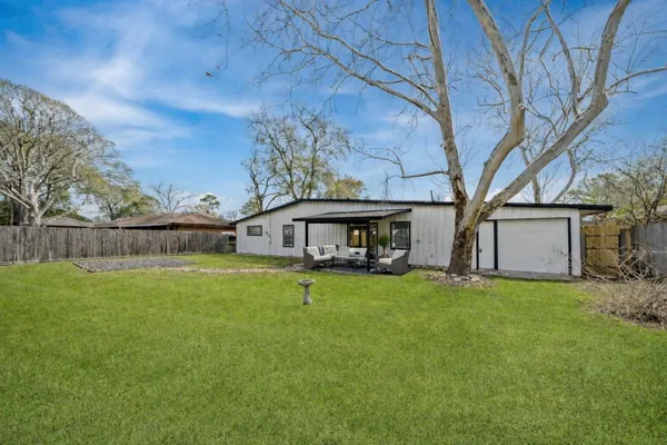 a view of a house with backyard and a tree