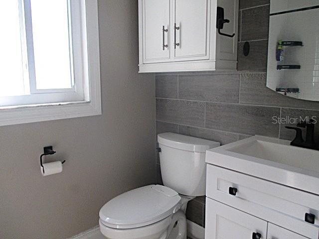 12932 81st Avenue Seminole, FL 33776 - Photo 13 of 27 a bathroom with a toilet a sink and mirror