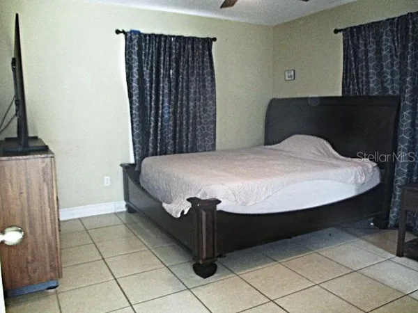 a bed sitting in a bedroom next to a window with wooden floor