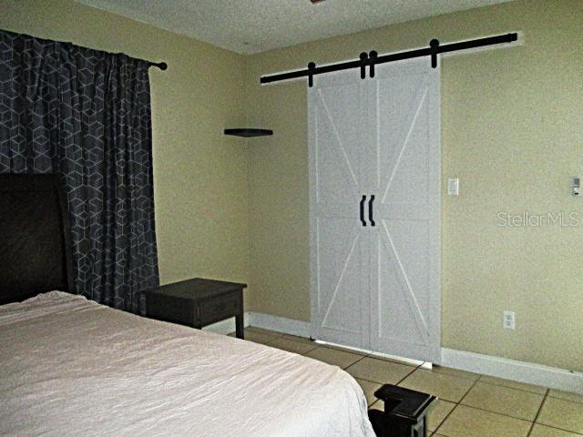 12932 81st Avenue Seminole, FL 33776 - Photo 10 of 27 a bedroom with a bed and a shower