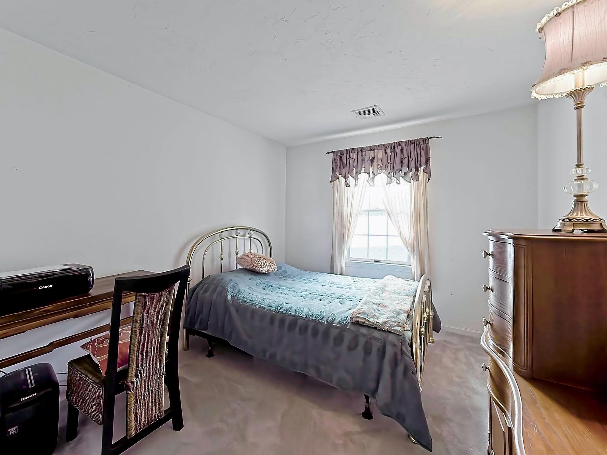 700 Shore Drive, Unit 1205 Fall River, MA 02721 - Photo 18 of 22 a bedroom with a bed chair and a flat tv screen on the dresser