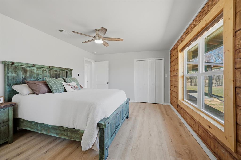 230 Frosty Hollow Road Denison, TX 75021 - Photo 28 of 40 a spacious bedroom with a bed and wooden floor
