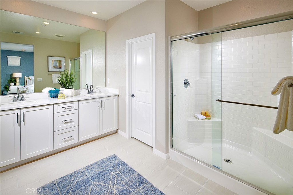 4084 Spring Lane Corona, CA 92883 - Photo 5 of 17 a spacious bathroom with a double vanity sink a mirror a bathtub and shower
