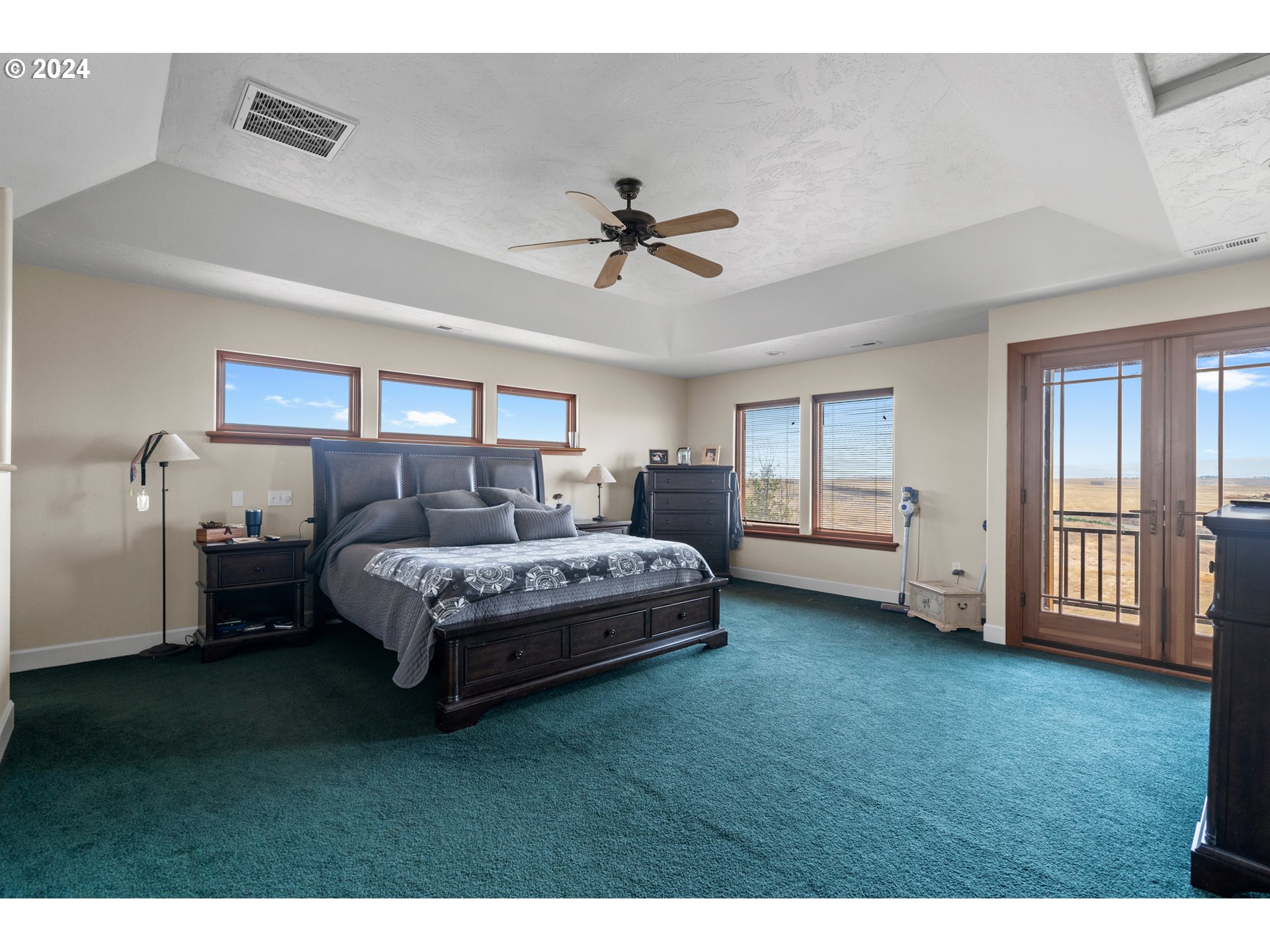 72217 Quill Point Pendleton, OR 97801 - Photo 13 of 48 a spacious bedroom with a bed a chandelier and a window